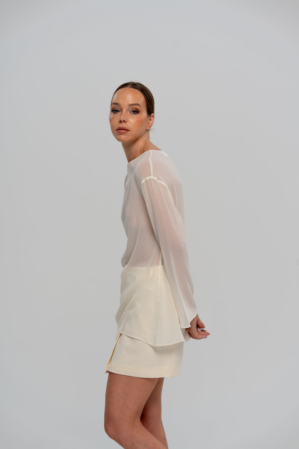 Solene Skirt in Ivory, side view styled with the sheer Ana Blouse, made in Italy by The Ethos Studio