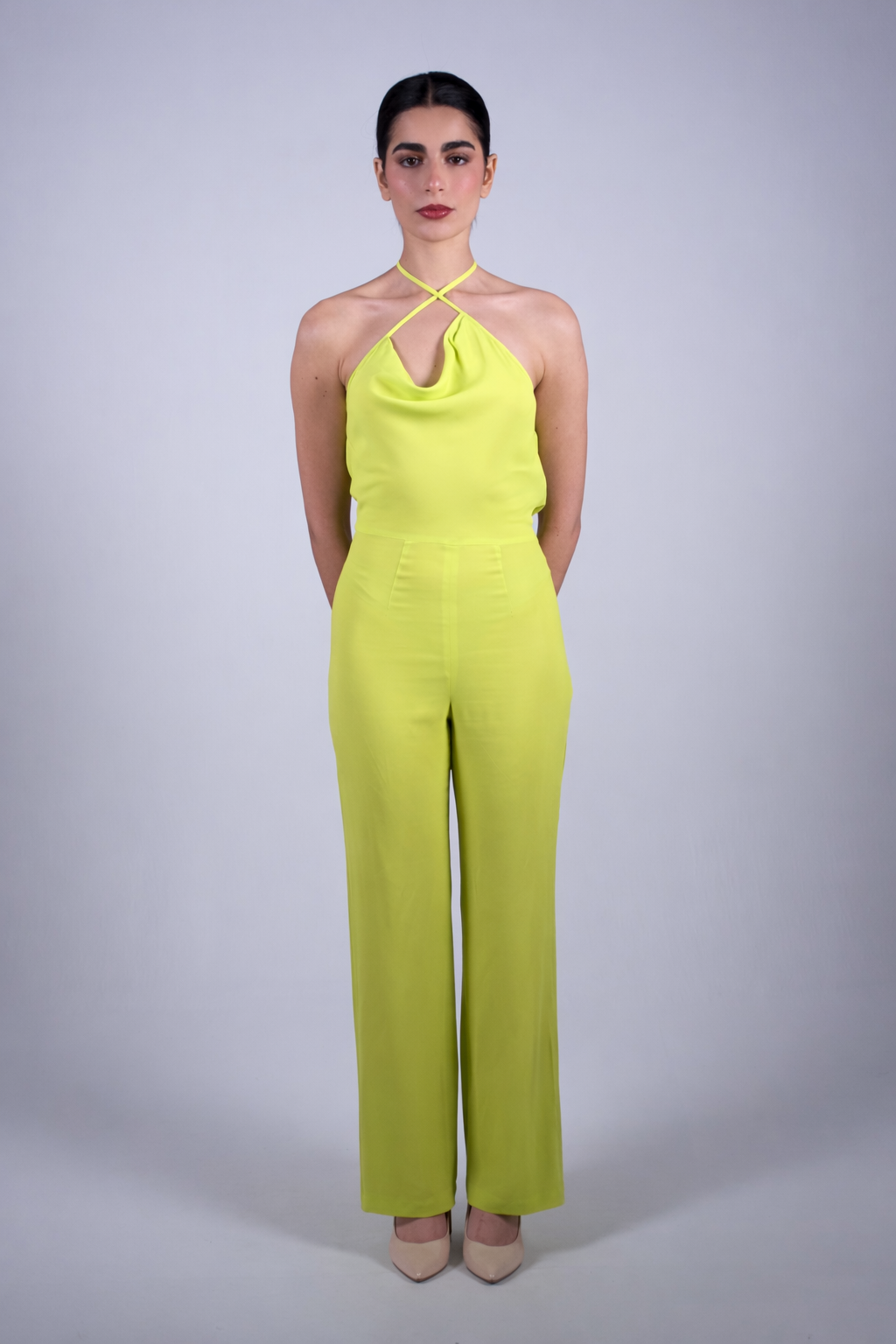 Woman wearing a bright yellow/lime jumpsuit against a plain background by The Ethos Studio